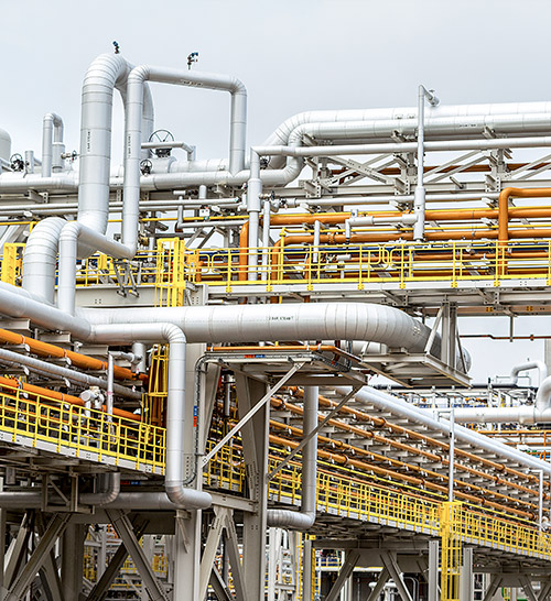 A kilometer-long network of pipes and pipe bridges interconnects the various production buildings on the 550-acre lot. (photo)