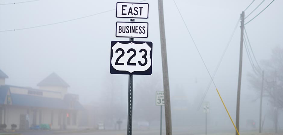 Road sign in foggy surrounding (photo)