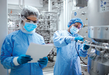 Scientists next to a fermenter (Photo)