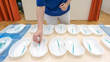 Prepared vaccine doses are placed on a table. (Photo)